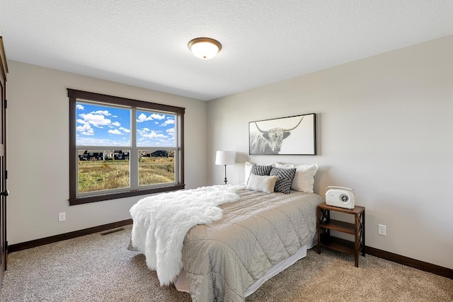 bedroom featuring light carpet and a textured ceiling