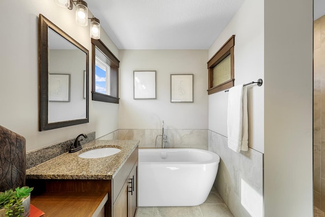 bathroom featuring vanity, tile walls, tile patterned flooring, and a washtub