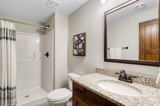 bathroom featuring vanity, toilet, a textured ceiling, and a shower with curtain