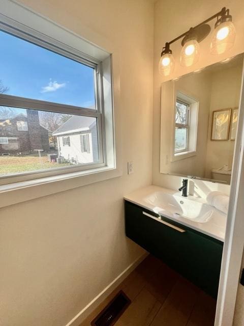 bathroom featuring vanity, toilet, and plenty of natural light