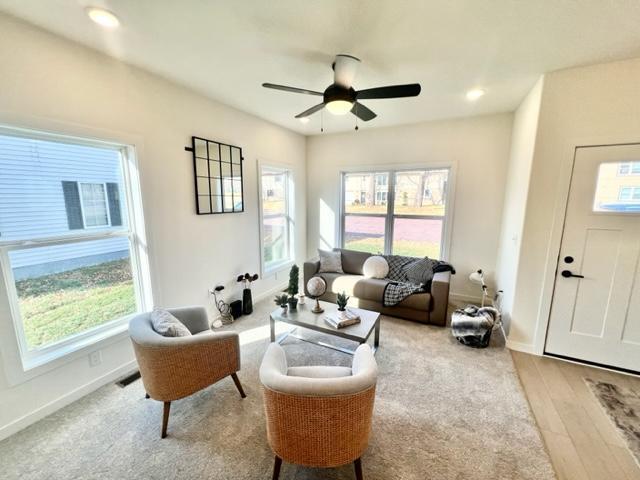 living room with light hardwood / wood-style floors and ceiling fan