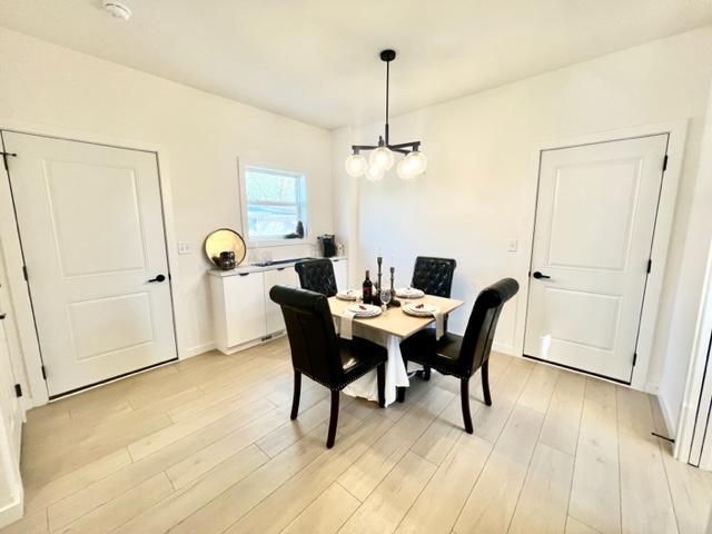 516 Elm St, Redwood Falls, MN 56283 - dining area featuring light wood-type flooring and a chandelier