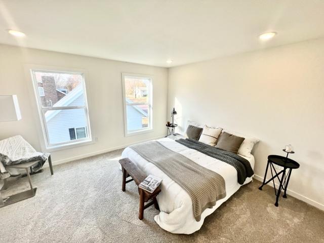 bedroom with multiple windows and carpet floors