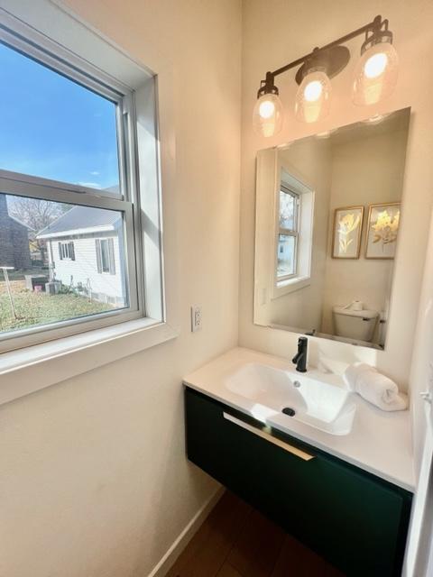 bathroom featuring a wealth of natural light, vanity, and toilet