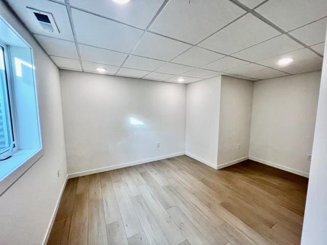 unfurnished room with light hardwood / wood-style flooring and a drop ceiling