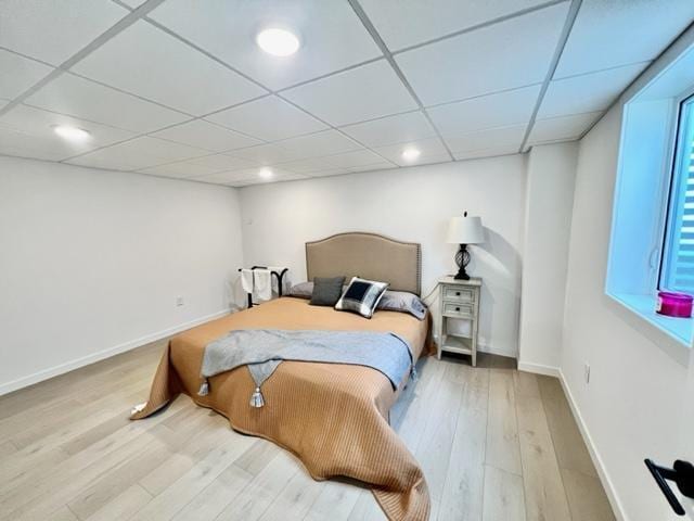 bedroom featuring a drop ceiling and wood-type flooring