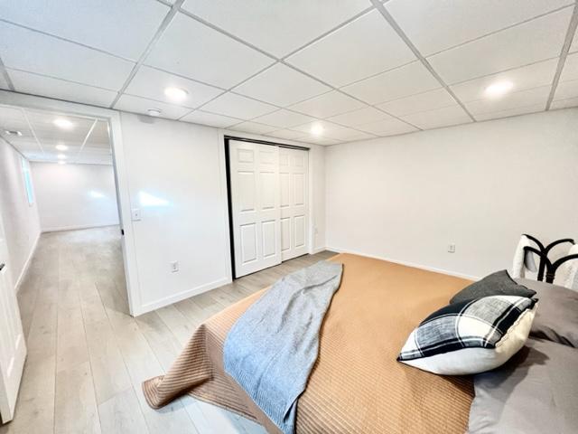 sitting room featuring light hardwood / wood-style floors and a drop ceiling