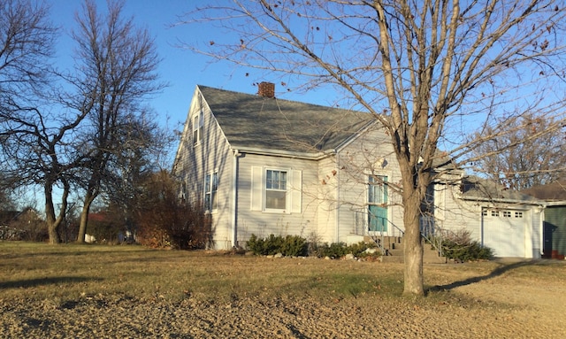 view of side of home with a lawn and a garage