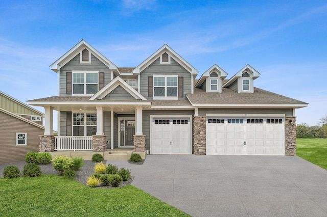 view of front of house with a porch, a front yard, and a garage