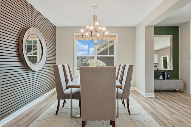 dining space featuring an inviting chandelier and light wood-type flooring