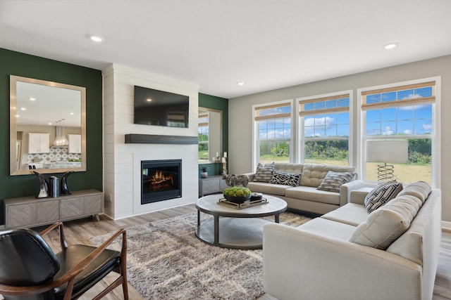 living room with light hardwood / wood-style floors and a large fireplace