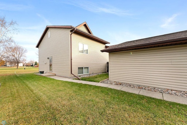 view of side of home with a yard