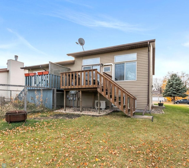 rear view of house featuring an outdoor fire pit, a lawn, and a wooden deck