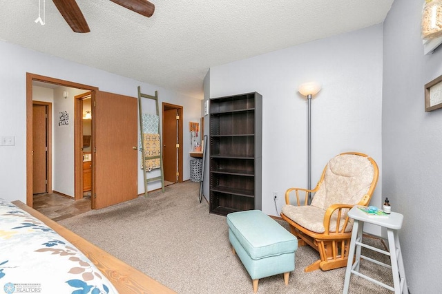 carpeted bedroom featuring ceiling fan and a textured ceiling