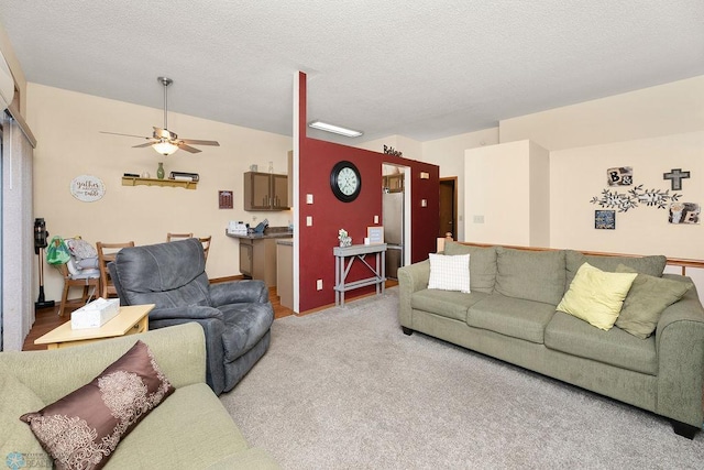 living room featuring ceiling fan, light colored carpet, and a textured ceiling