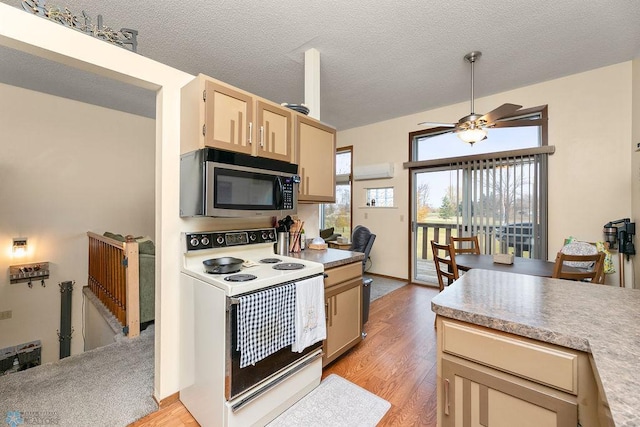 kitchen featuring a textured ceiling, ceiling fan, light brown cabinets, light hardwood / wood-style flooring, and white electric stove