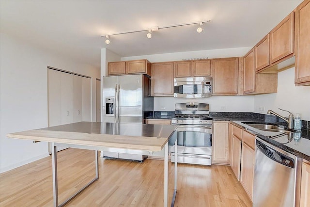 kitchen featuring appliances with stainless steel finishes, light hardwood / wood-style floors, and sink