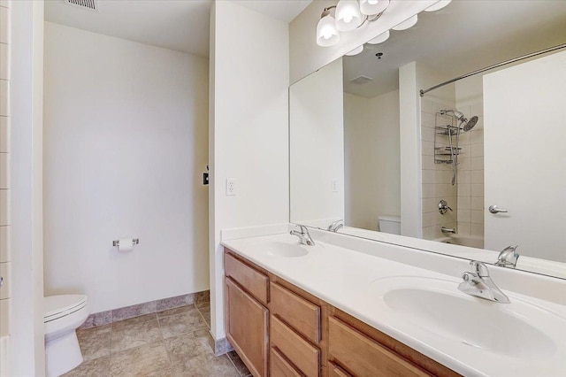 full bathroom with tiled shower / bath combo, toilet, and vanity