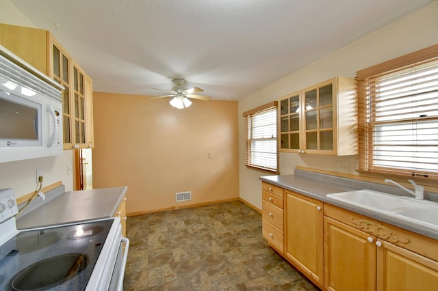 kitchen with white appliances, ceiling fan, light brown cabinetry, and sink