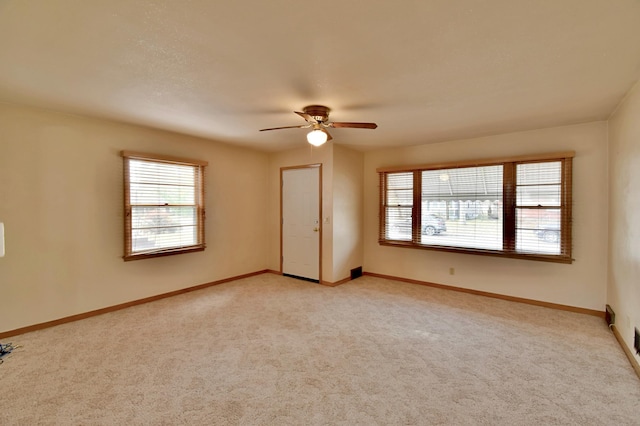 spare room with light colored carpet and ceiling fan