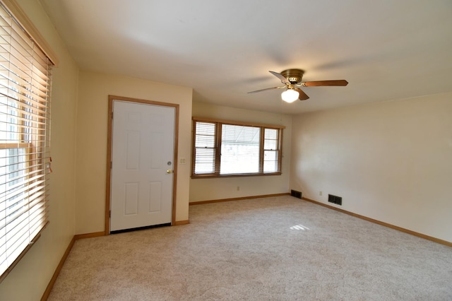 carpeted spare room with ceiling fan