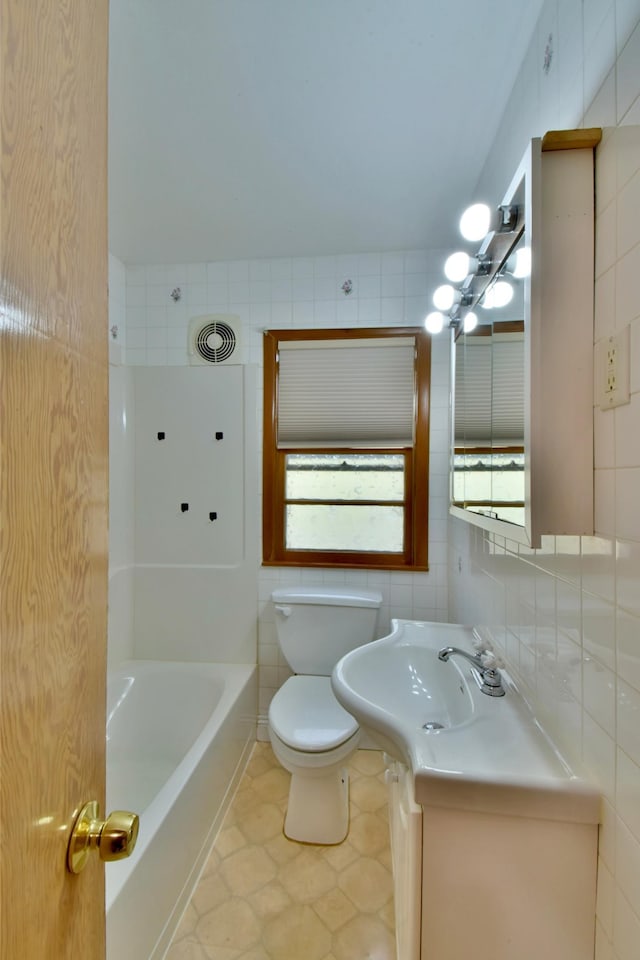 bathroom featuring tasteful backsplash, tile walls, vanity, tile patterned flooring, and toilet