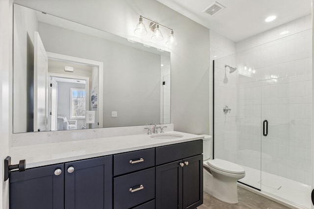 bathroom featuring a shower with door, vanity, and toilet