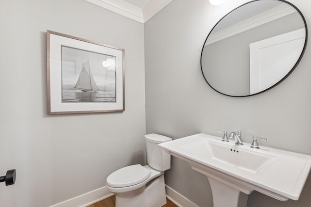 bathroom with toilet, crown molding, and hardwood / wood-style floors