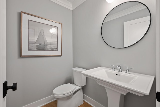 bathroom featuring toilet, ornamental molding, and wood-type flooring