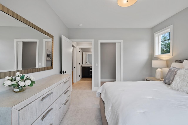 bedroom with light carpet and ensuite bathroom