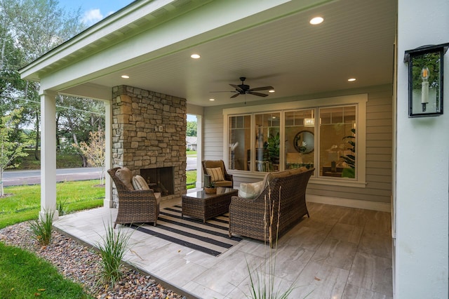 view of patio / terrace with ceiling fan and an outdoor living space with a fireplace