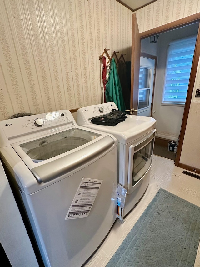 laundry area with laundry area, baseboards, washing machine and clothes dryer, and wallpapered walls