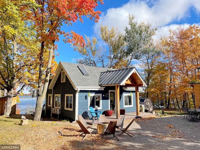 view of front of home featuring a patio, an outdoor fire pit, and a water view