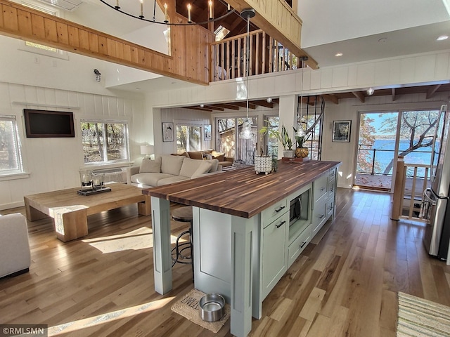 interior space featuring plenty of natural light, light wood-type flooring, high vaulted ceiling, and wood counters