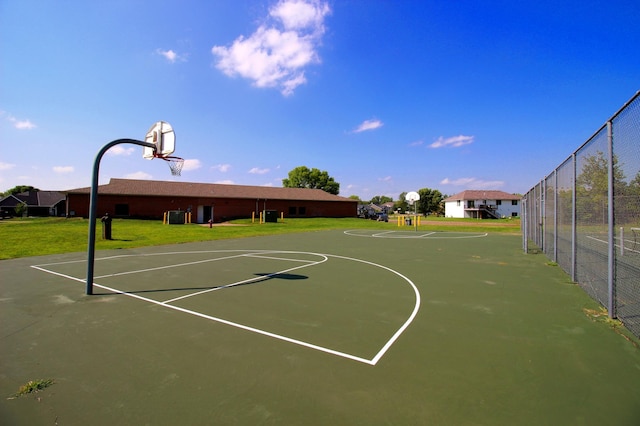 view of sport court with a lawn