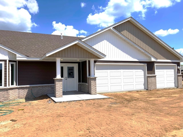 1067 241st Ln NE, East Bethel, MN 55005 - view of front of property with brick siding, a garage, a shingled roof, covered porch, and driveway
