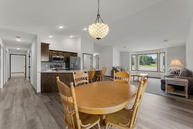 1067 241st Ln NE, East Bethel, MN 55005 - dining space with vaulted ceiling, light wood-style flooring, and recessed lighting