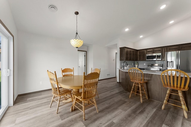 1067 241st Ln NE, East Bethel, MN 55005 - dining room featuring light wood-style floors, recessed lighting, and vaulted ceiling