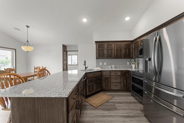 1067 241st Ln NE, East Bethel, MN 55005 - kitchen featuring stainless steel appliances, dark brown cabinets, a peninsula, tasteful backsplash, and light wood-type flooring