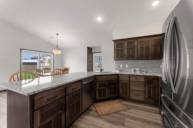 1067 241st Ln NE, East Bethel, MN 55005 - kitchen with appliances with stainless steel finishes, a peninsula, decorative backsplash, light wood-style floors, and lofted ceiling