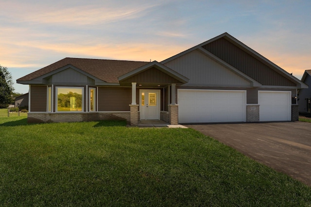 1067 241st Ln NE, East Bethel, MN 55005 - view of front of home featuring brick siding, an attached garage, driveway, a front yard, and roof with shingles