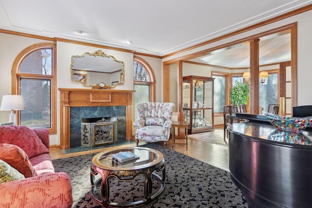 living room featuring a high end fireplace, wood-type flooring, and ornamental molding