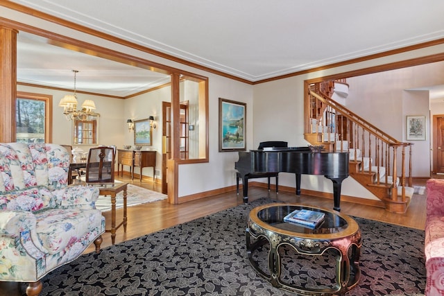 living room with wood-type flooring, ornamental molding, and a notable chandelier