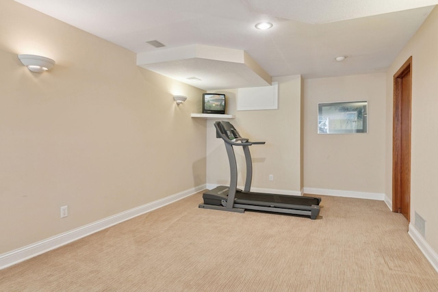 exercise room featuring light carpet