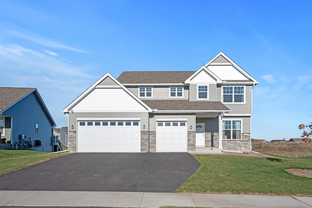 craftsman house with a garage and a front lawn