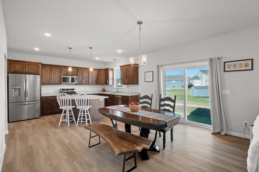 dining area featuring baseboards, light wood-type flooring, and recessed lighting