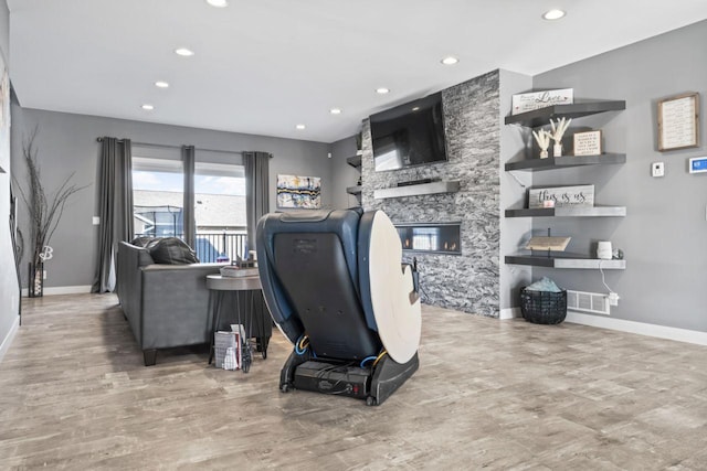 interior space with hardwood / wood-style floors and a stone fireplace