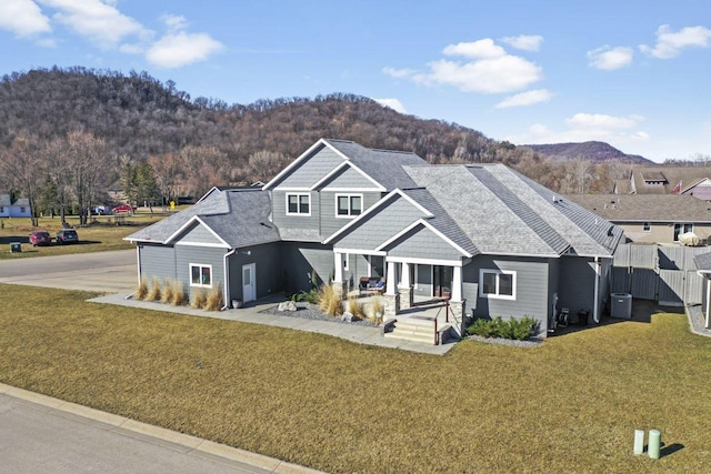 view of front of house with a front lawn, central air condition unit, and a mountain view