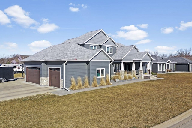 craftsman house featuring a garage and a front lawn