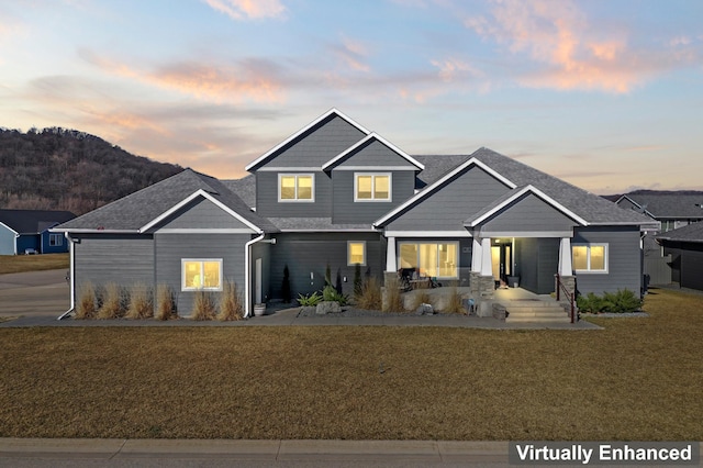 craftsman house with a yard, a mountain view, and a porch